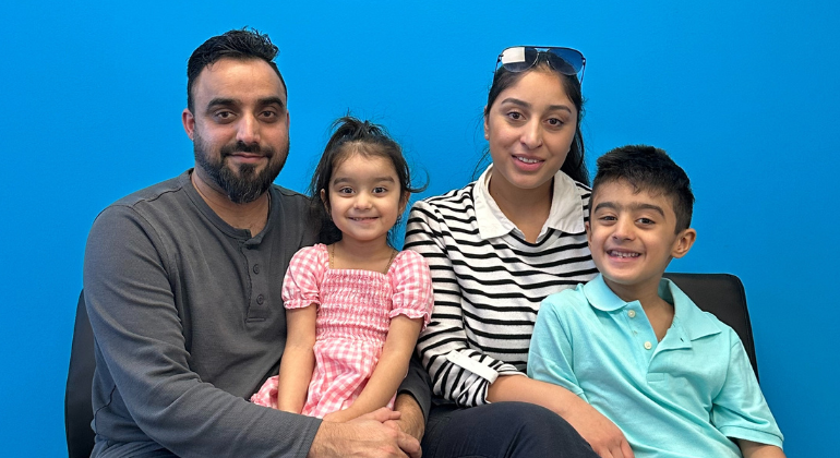 Muhammad and Iqra with their 6 year old son and 3 year old daughter smiling proudly.