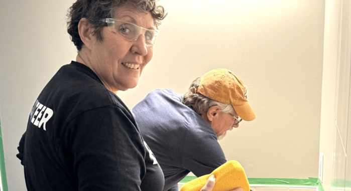 Liz shown working with another volunteer to install tile backsplash