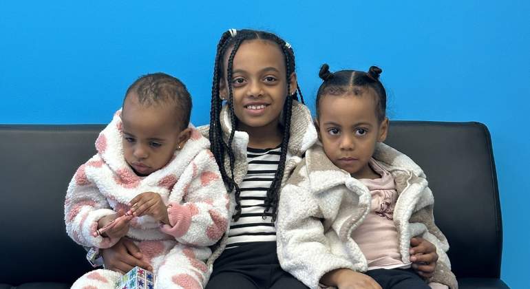 Habtom and Mihret's three young daughters sit side by side smiling