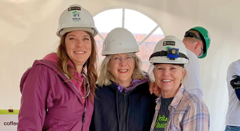 Sue smiles for a photo with two close friends from the Habitat build site.