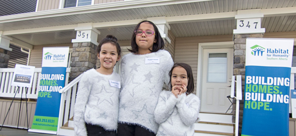 family in front of their new Habitat home