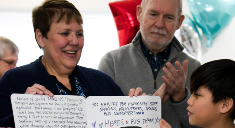 Local committee volunteer Marilyn accepts a giant card full of thank you wishes.