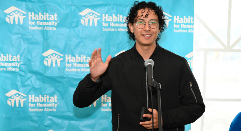 Santiago smiles while delivering a speech at a Habitat home event.