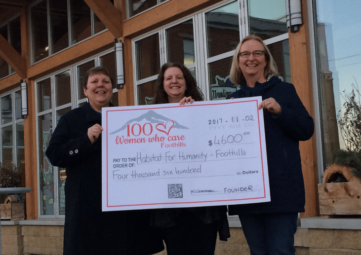 Marilyn accepting a large cheque for a $4600 donation from 100 Women Who Care Foothills