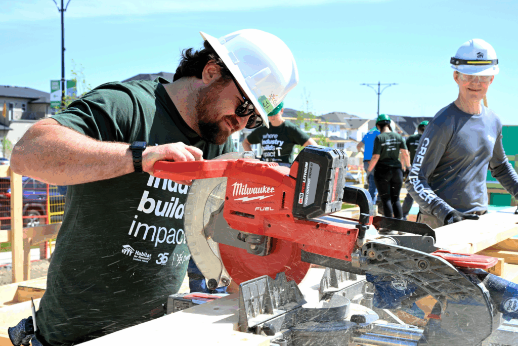 Man using power tool to cut a plank of wood at Industry Build event