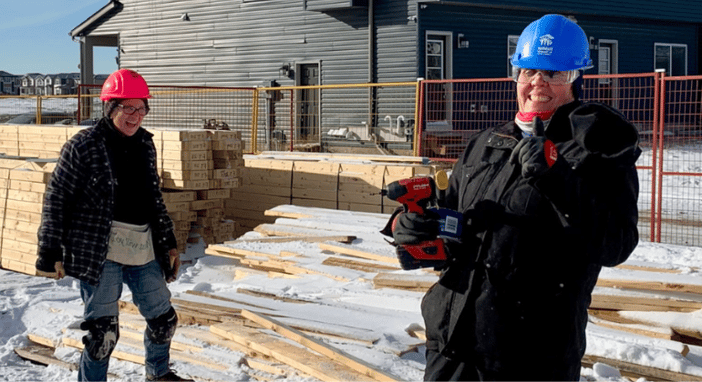 Liz and another volunteer sharing a laugh on the construction site