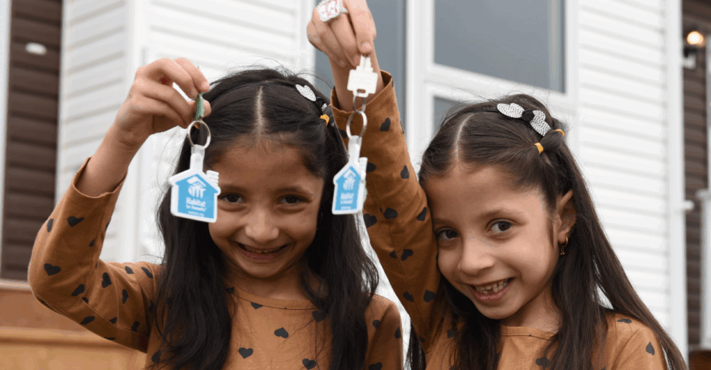 Twin girls show off their new house keys.