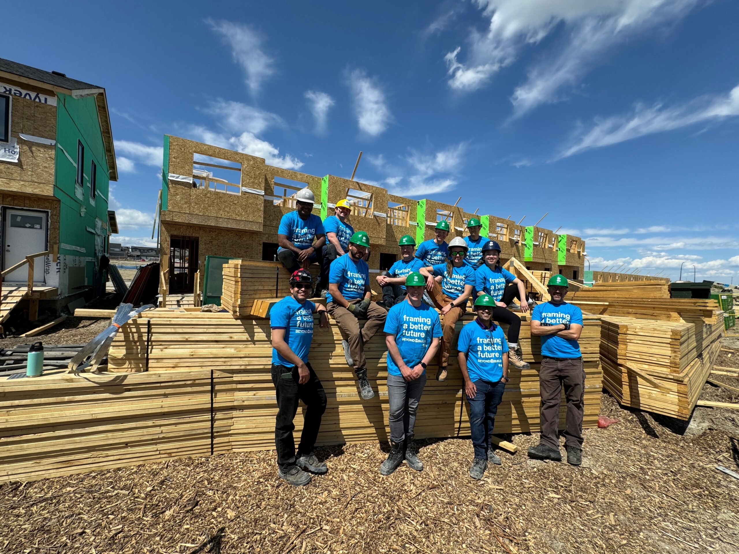 A group of people sitting on a stack of wood on a construction site
