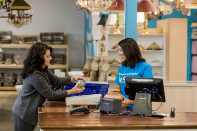 A woman making a purchase at a ReStore till