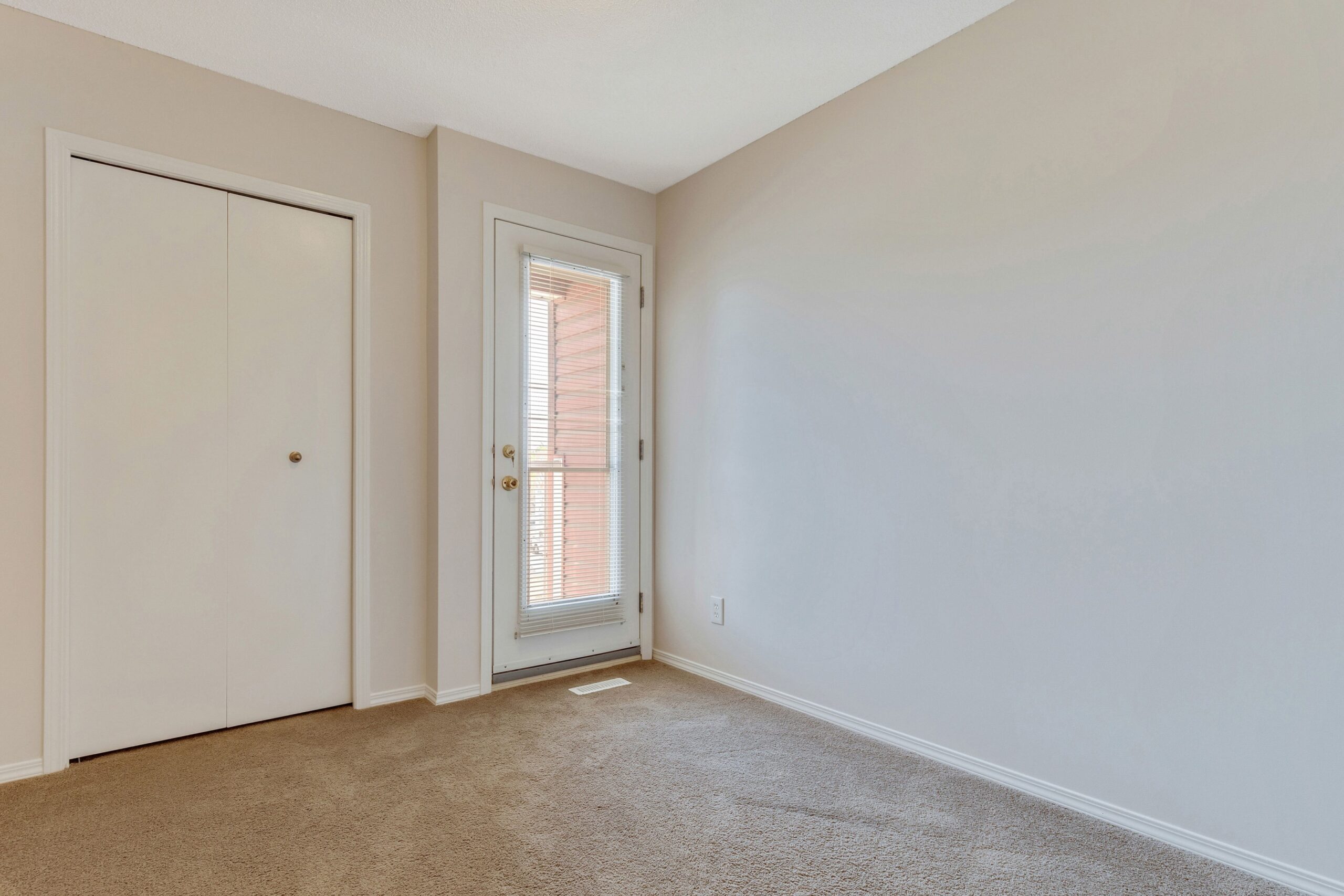 Unoccupied master suite of a Habitat home in Calgary showing the private balcony.