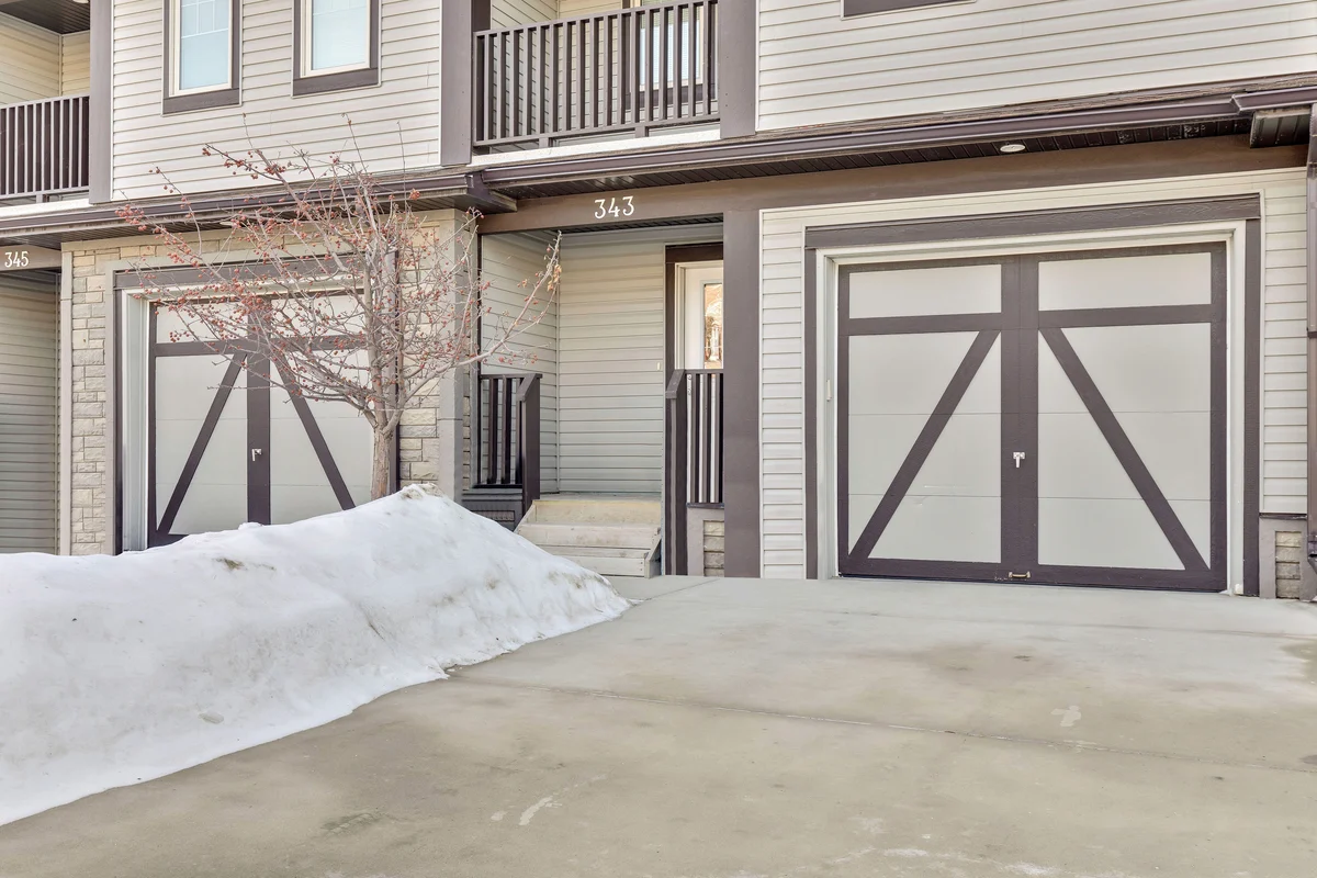 Close up of a Habitat townhome exterior showing the driveway and attached garage.