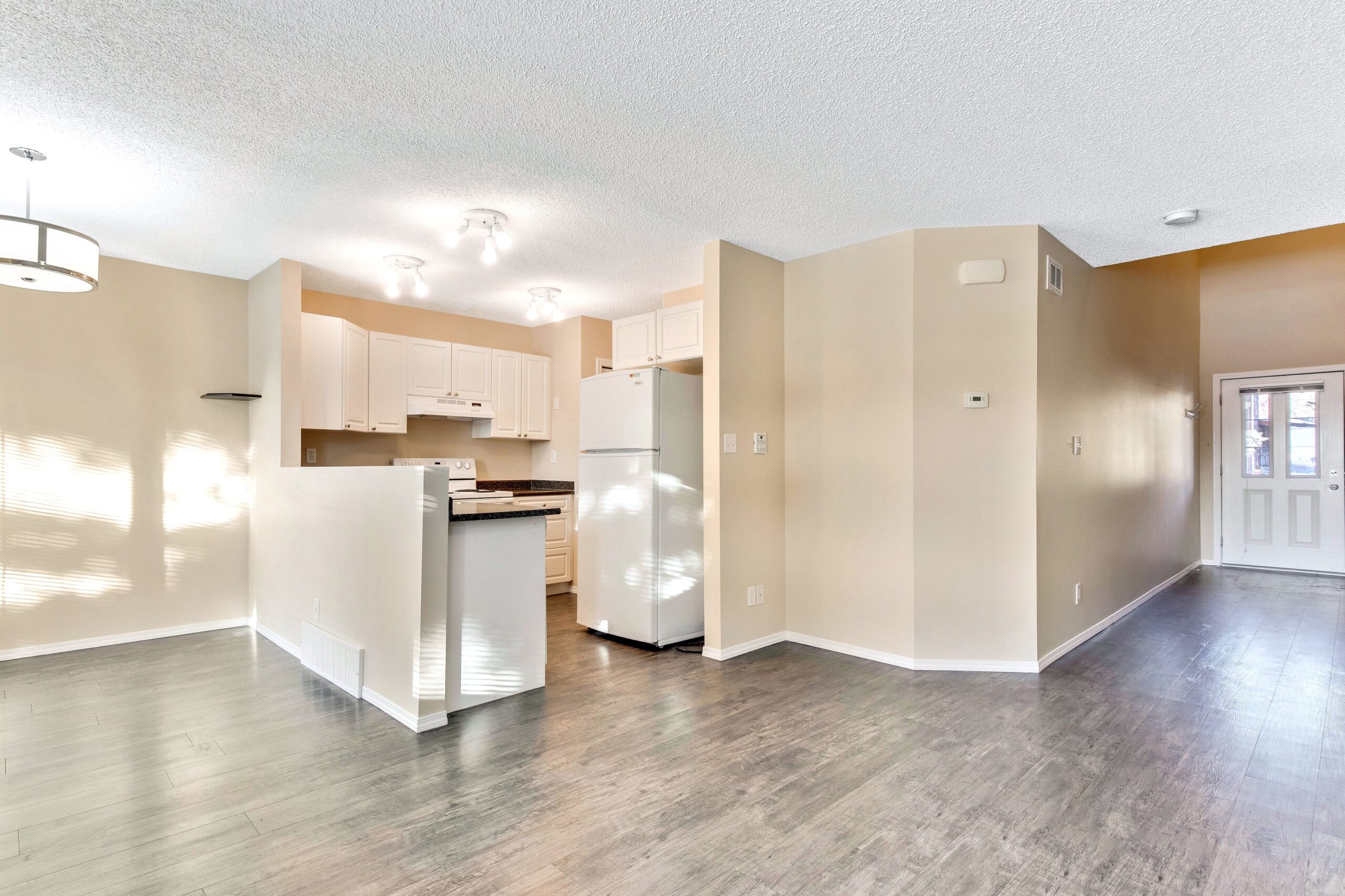 Open concept main floor of a Habitat home in Cochrane showing the kitchen and dining rooms.