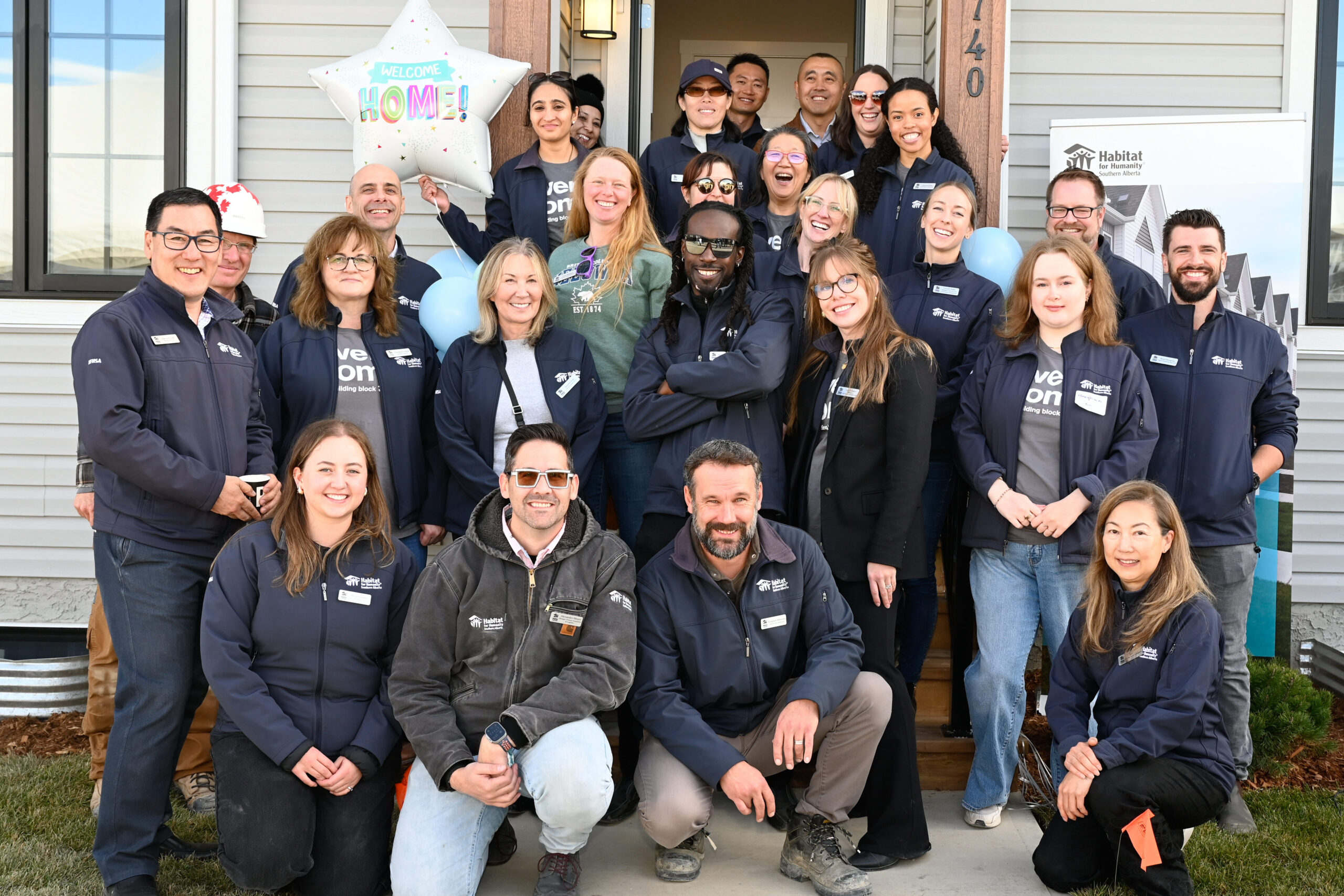 Habitat staff gather in front of a finished home in Calgary.