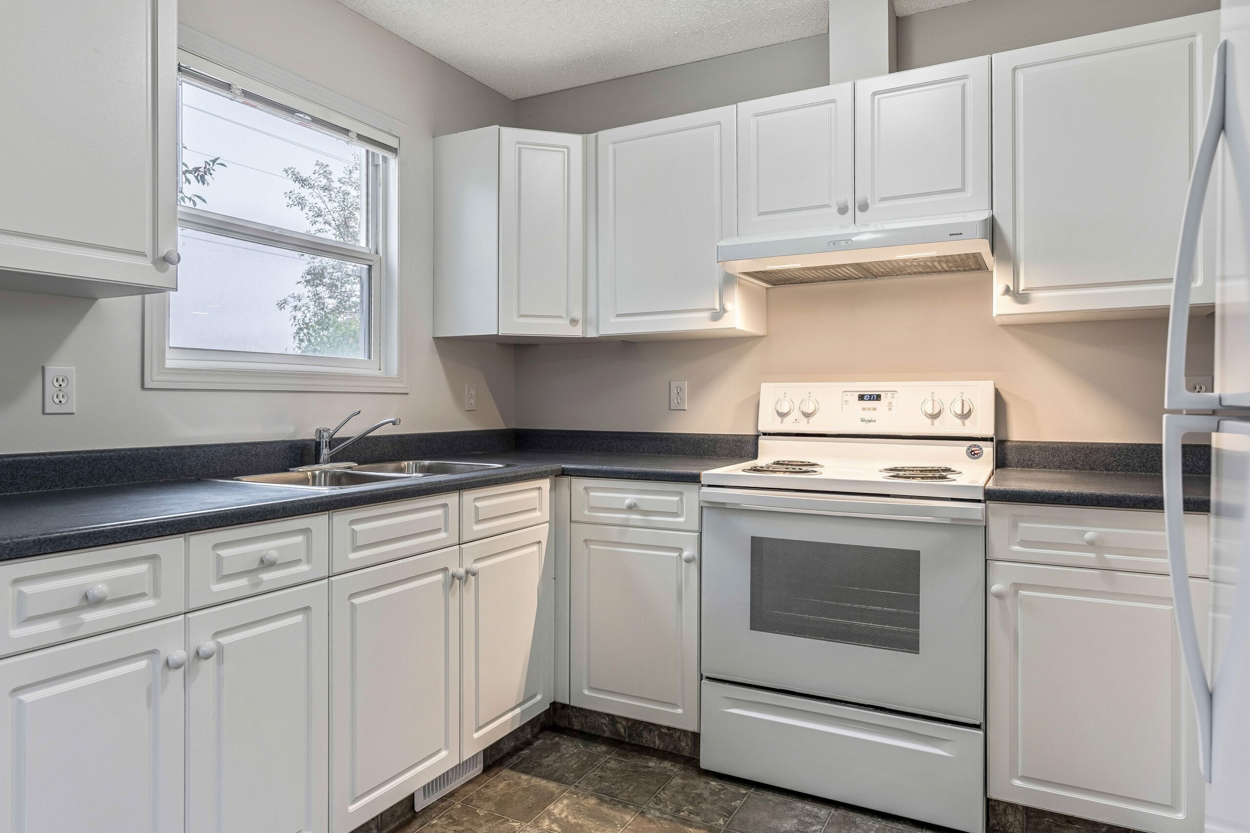 White kitchen with dark countertops in a Habitat home in Calgary.