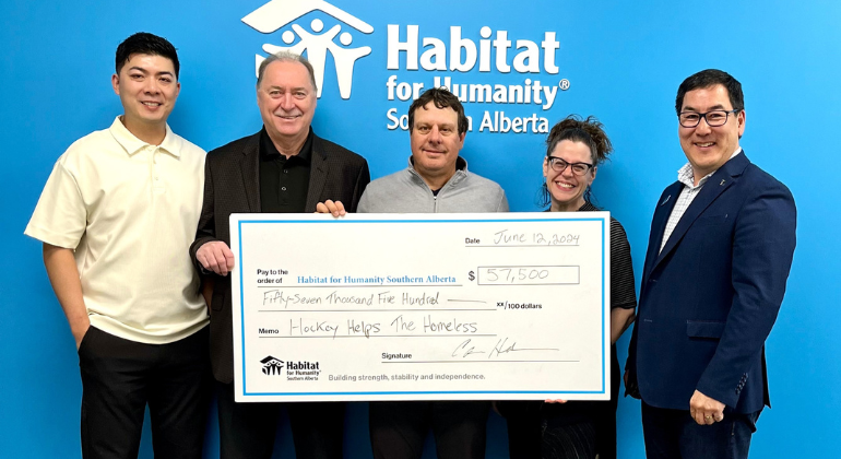 A cheque presentation from HHTH at the Habitat Southern Alberta head office