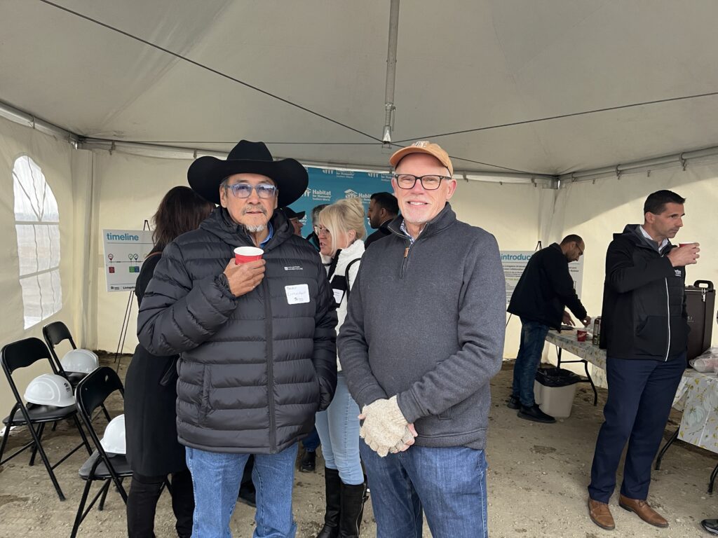 Russ stands with Elder Brian Littlechief at a Habitat groundbreaking event.