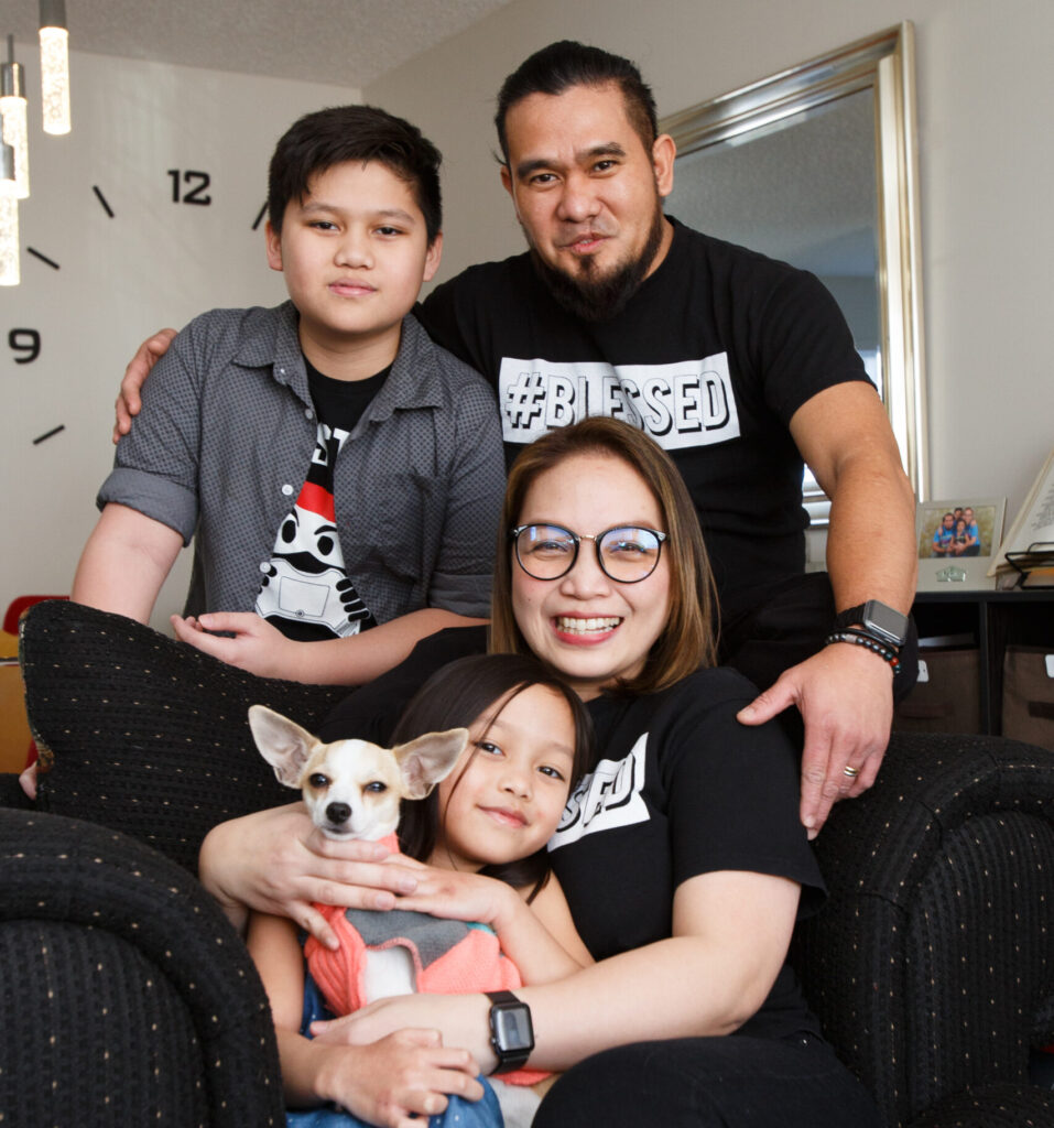 Avon and Romano with their two kids and dog in their affordable Habitat home.