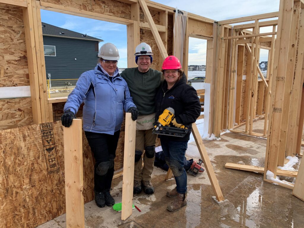 Three volunteers on a construction site outdoors