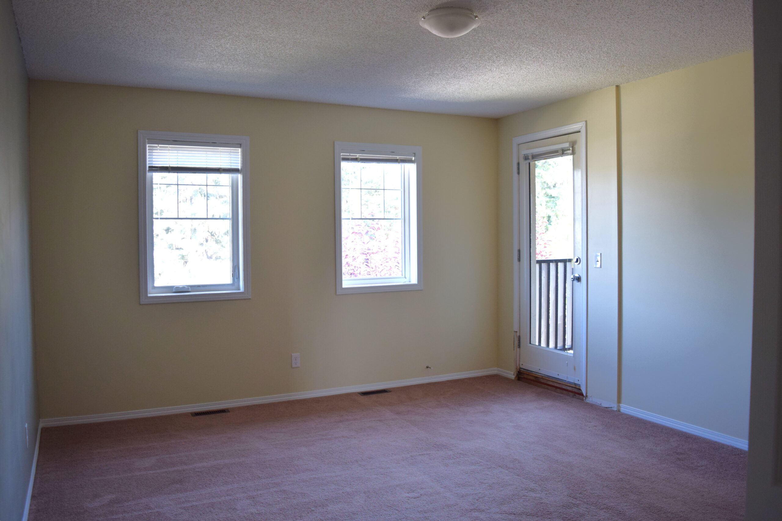 Empty owner's suite in a Habitat home with a private balcony.