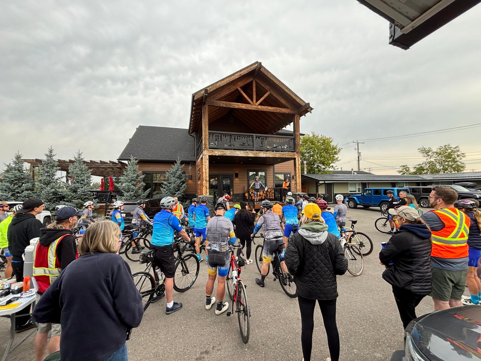 Cyclists and volunteers gather for a pre-ride safety meeting in Pincher Creek.