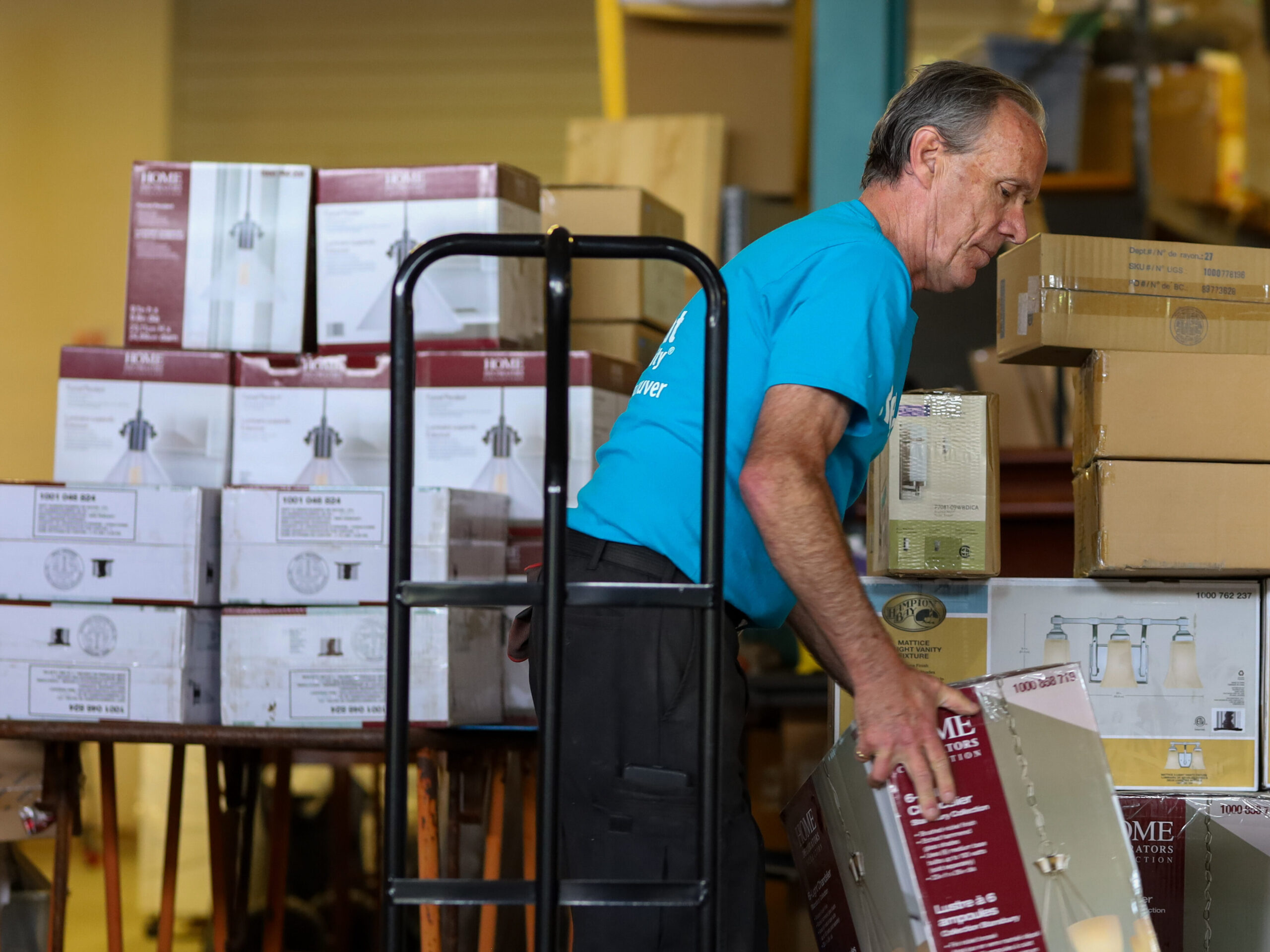 A volunteer unloads a corporate donation in a ReStore warehouse.
