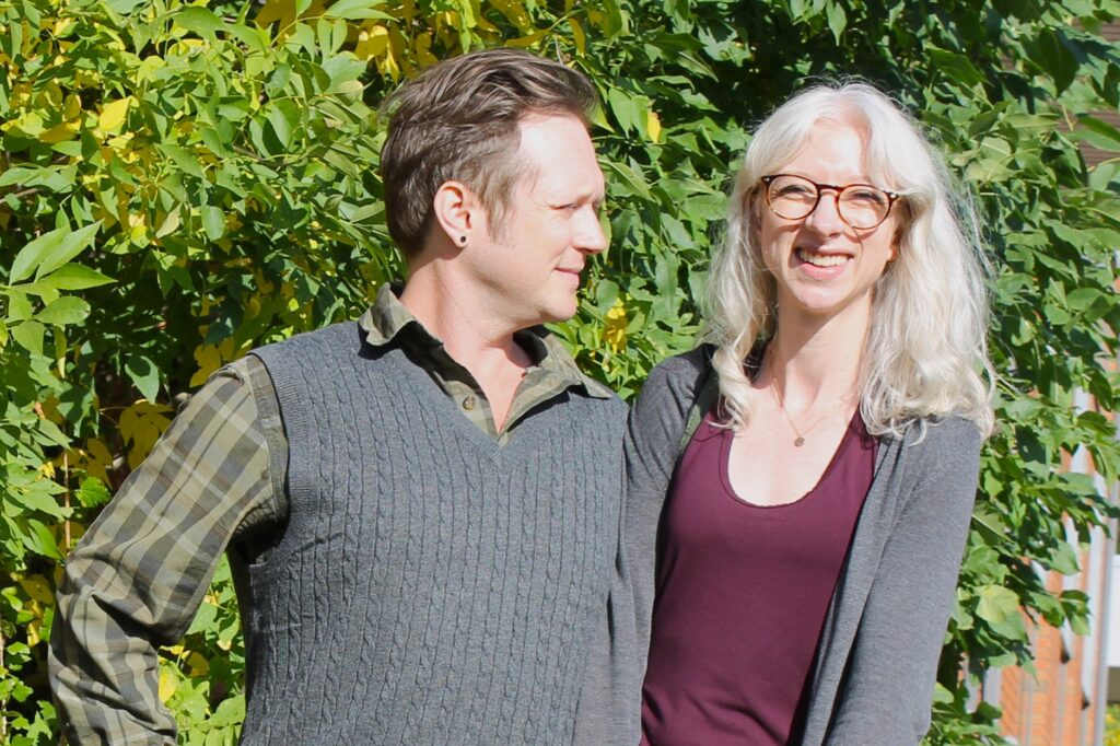Future Habitat homeowners Pamela and Joel in front of an autumn coloured tree.