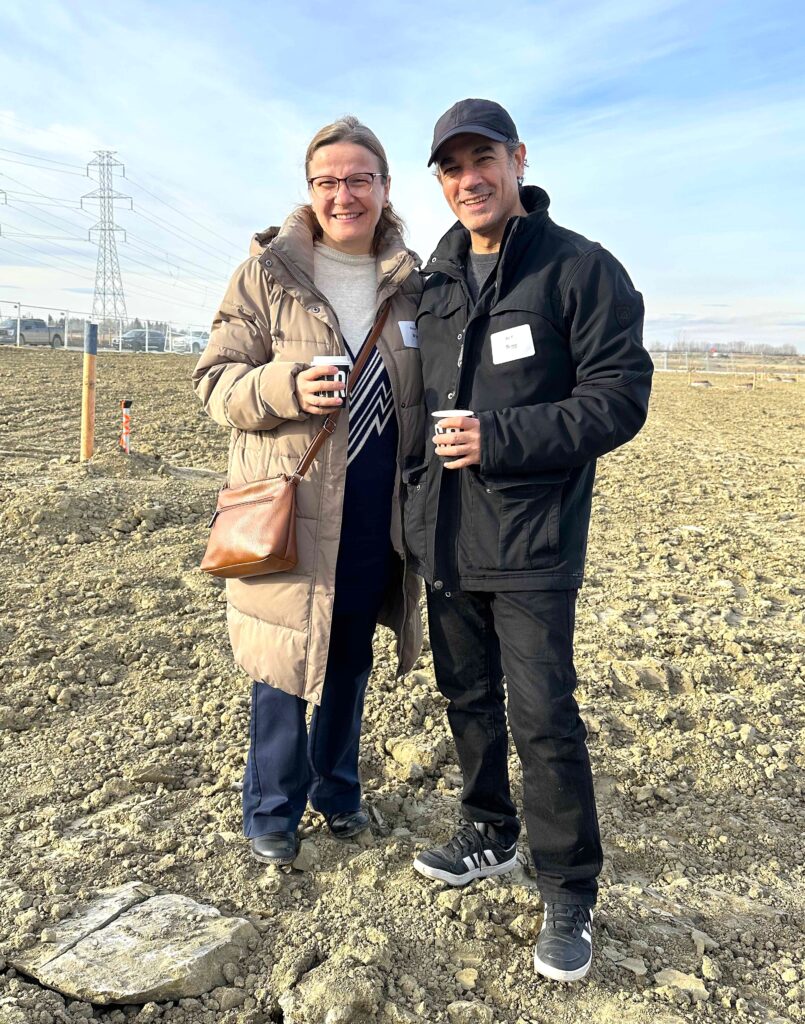 Ali and Ilknur stand on the empty lot where their future home will be built. 