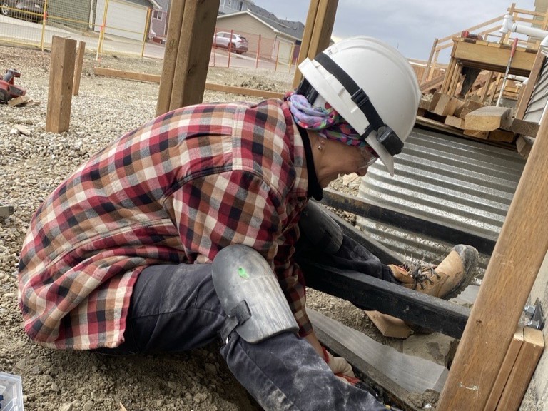 Volunteer Bev works on the exterior of a Habitat home in Airdrie.