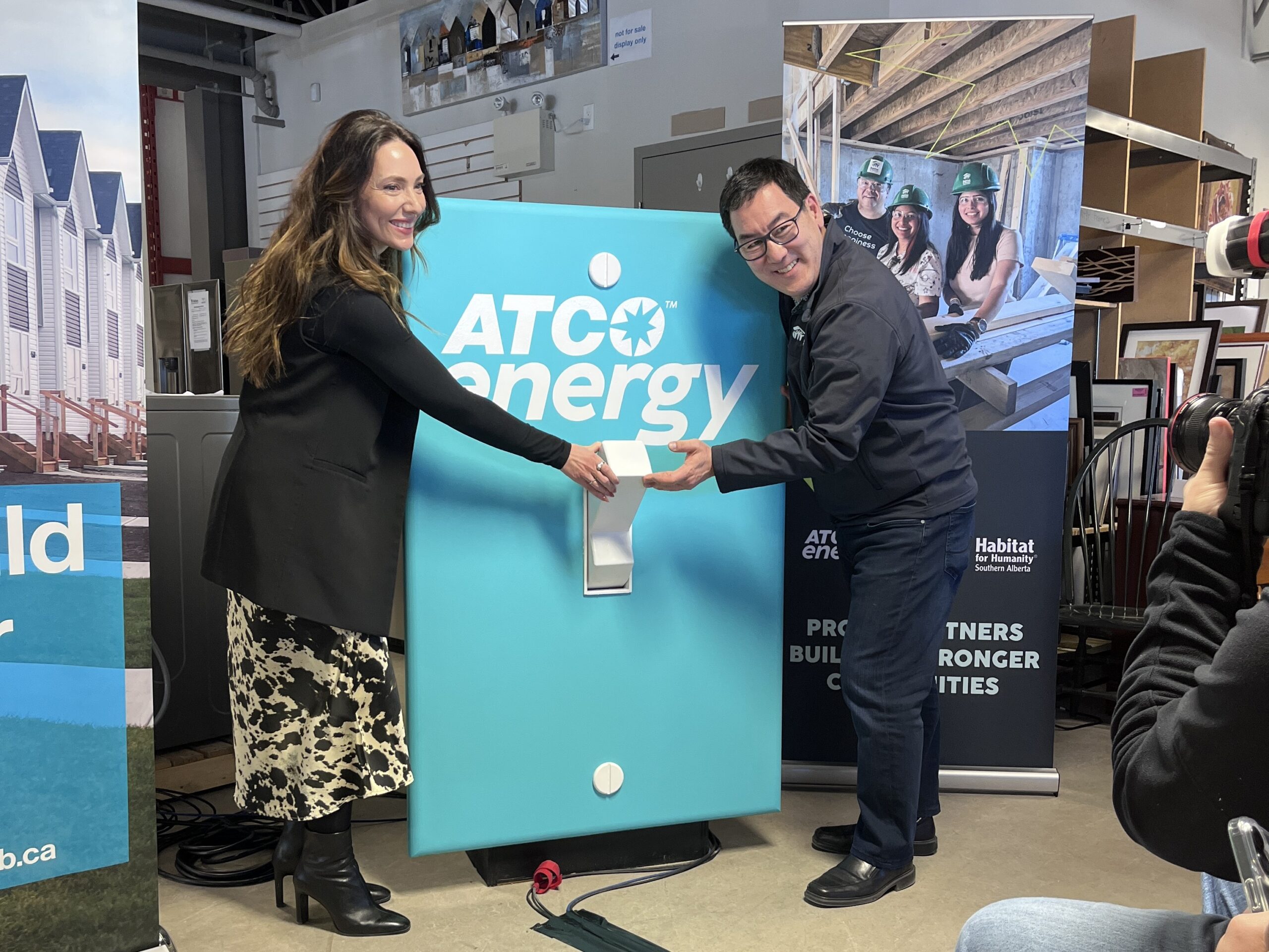 Habitat CEO Gerrad Oishi poses with ATCO's Lindsay Hagen celebrating powering up Habitat ReStore with ATCO Energy.