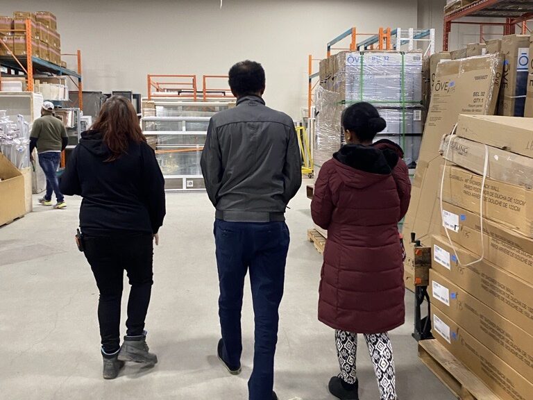 Three people walk through Habitat ReStore