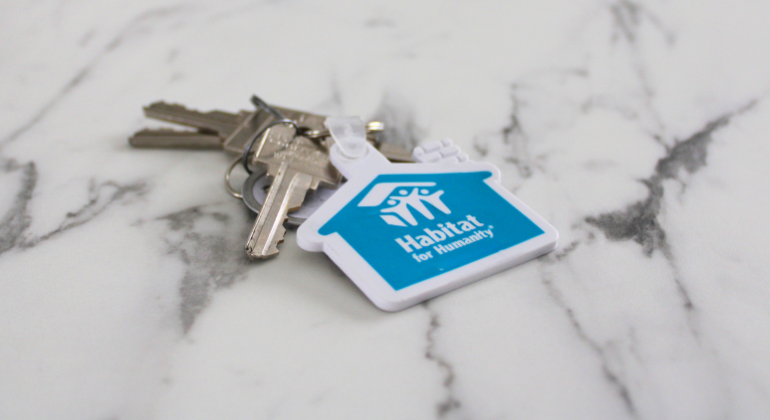 Habitat for Humanity blue house key chain with a few keys.