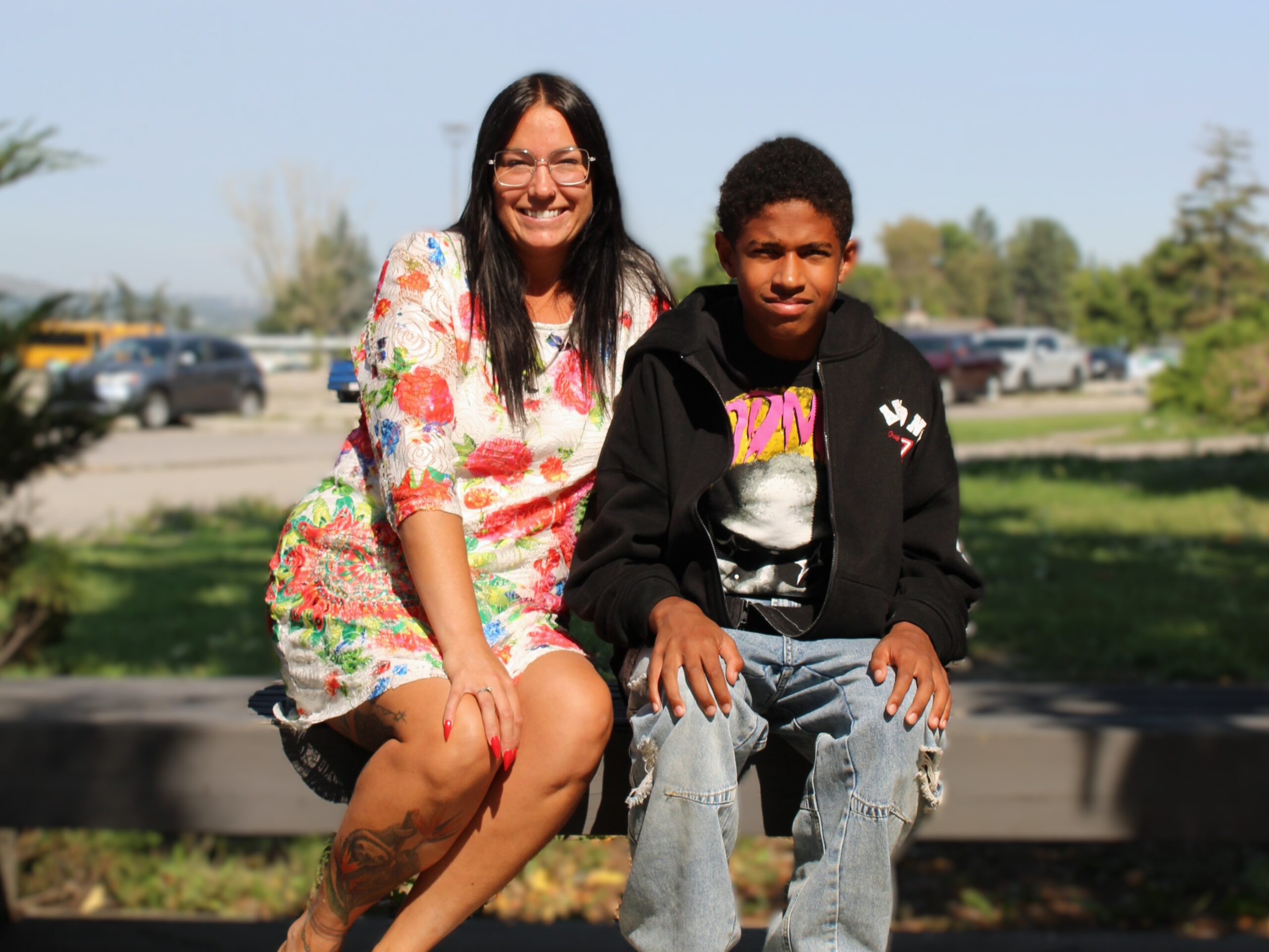 A mother and son together on a park bench.