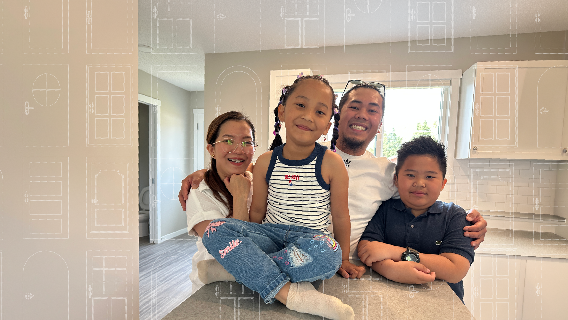 A family smiling sitting on a kitchen counter in their new affordable home