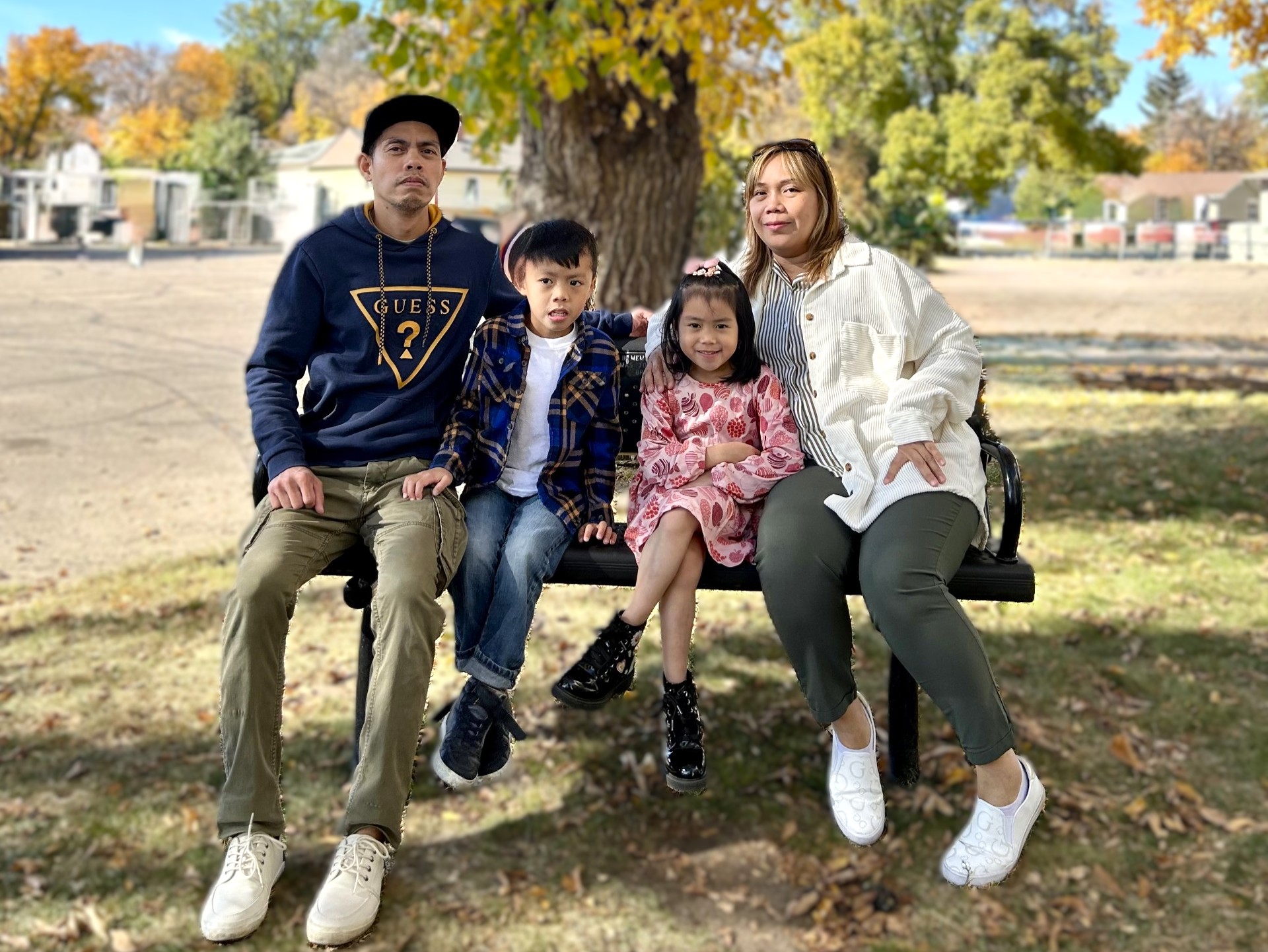 Ma Sheena Erwin and their two kids on a park bench.